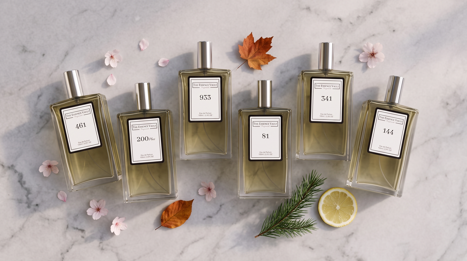 Six TEV perfume bottles with seasonal props on marble - cherry blossom, autumn leaf, pine, lemon